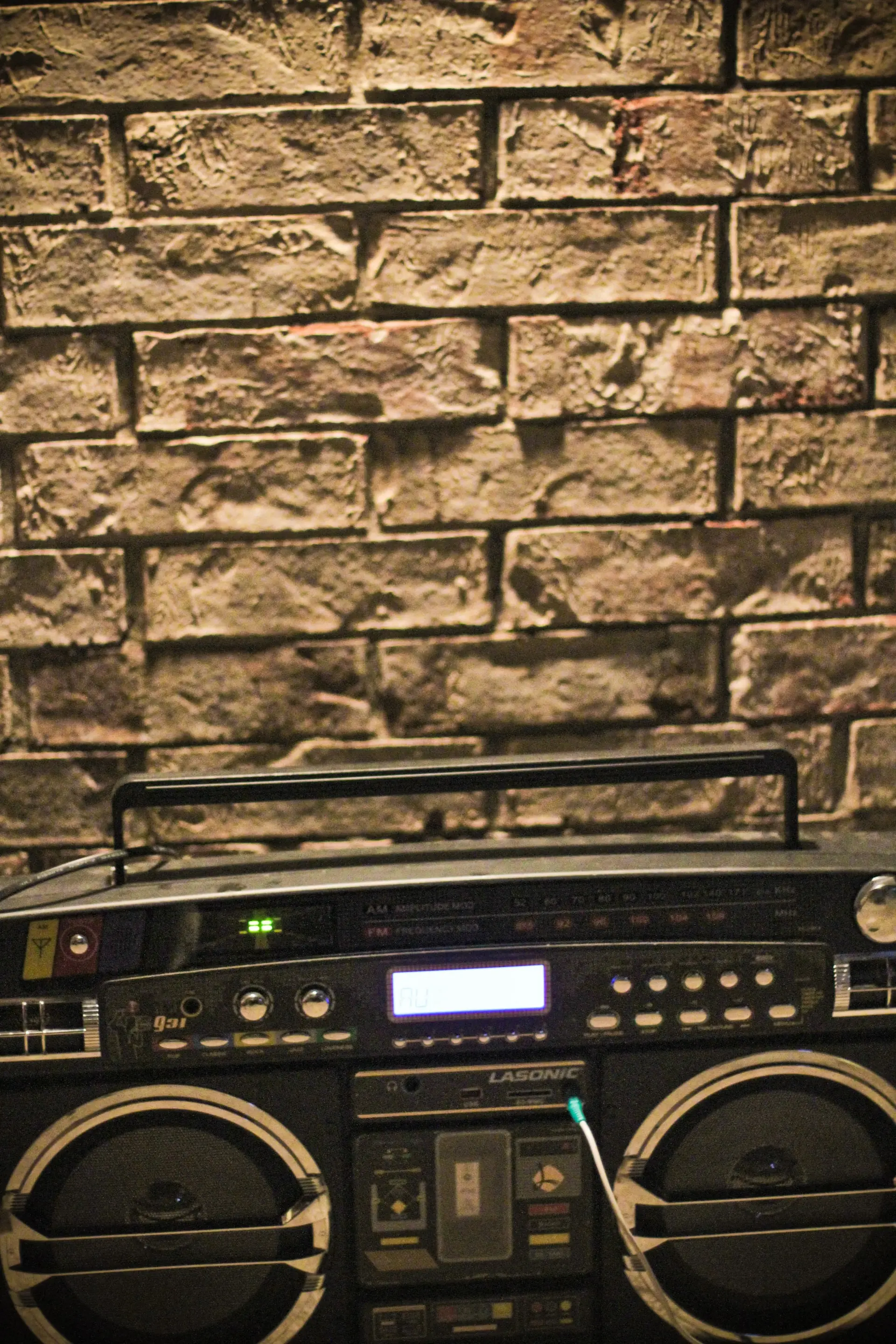 Boombox Lasonic chromé posé au sol, double lecteur cassette et haut-parleurs massifs, icône du ghetto blaster