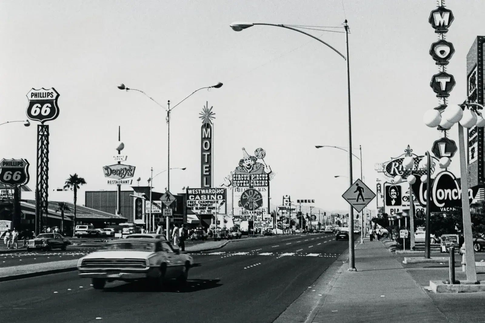 Rue de Las Vegas en noir et blanc : voiture ancienne, enseignes de motels et de casinos