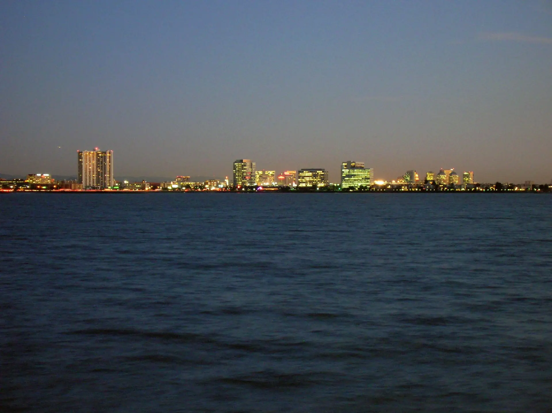 La skyline d’Oakland au crépuscule, tours du centre-ville se détachant sur un ciel orangé