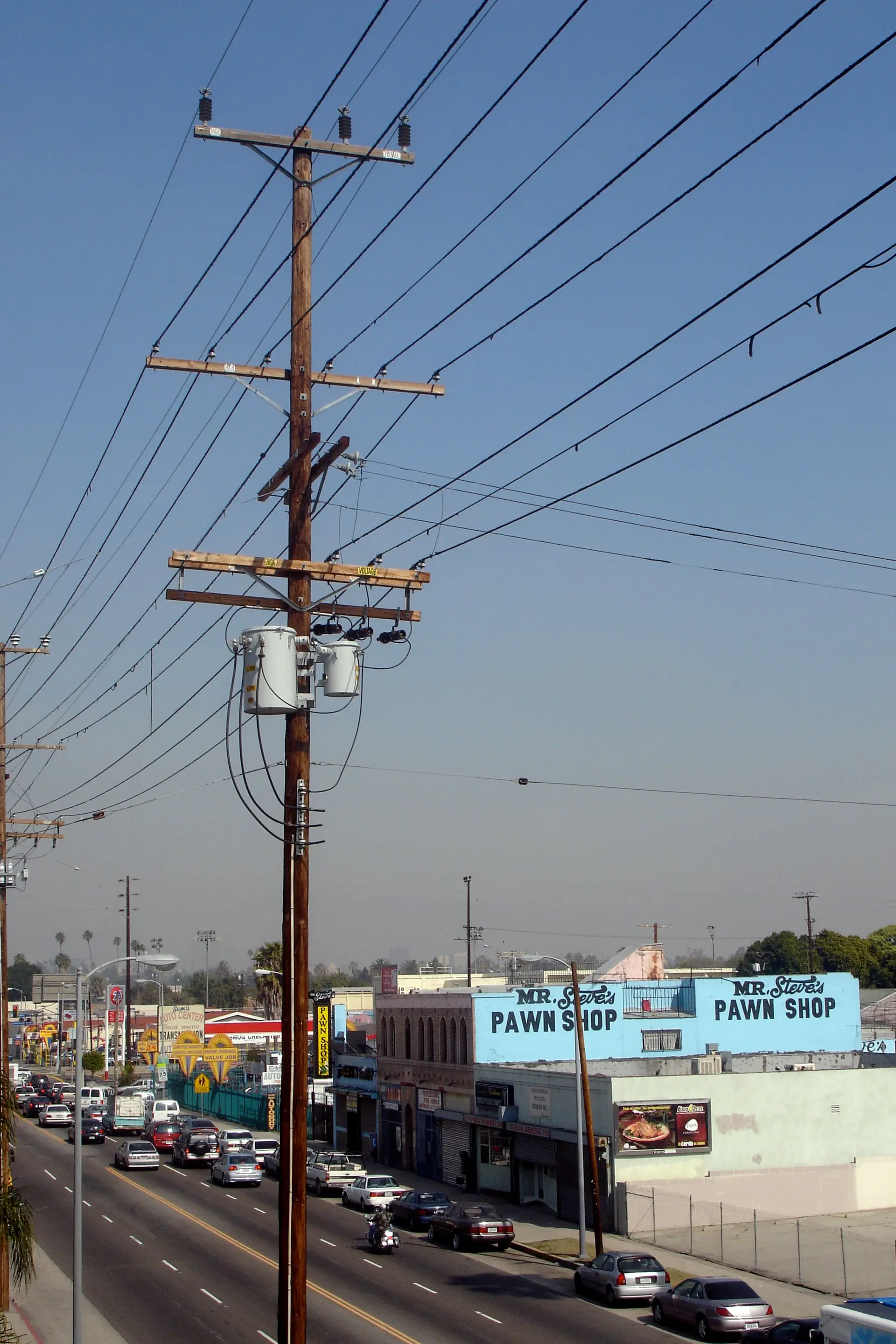 Western Avenue à South Central, Los Angeles : rue résidentielle, maisons basses et palmiers dégingandés contre le ciel